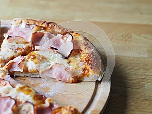 baked and sliced â€‹â€‹pizza with cheese, ham and sauce