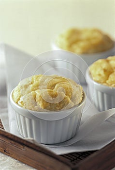 Baked souffle in three white containers on wooden tray