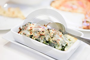 Baked spinach with cheese is easily made by smothering the spinach in cheese sauce and baking it until golden and bubbly