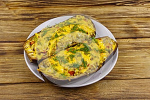 Baked stuffed eggplants on wooden table. Healthy food and dieting concept