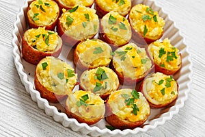 baked stuffed red potato on white baking dish