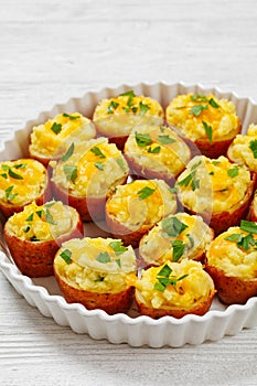 baked stuffed red potato on white baking dish