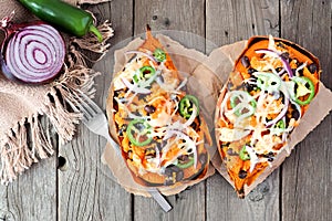 Baked, stuffed sweet potatoes, above view on rustic wood