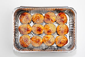 Baked sushi rolls in a foil box container