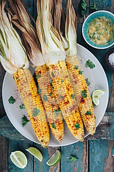 Baked sweet corn cobs with herb butter and lime