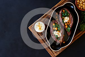 Baked sweet potato filled with kale and chickpeas . Top view with copy space