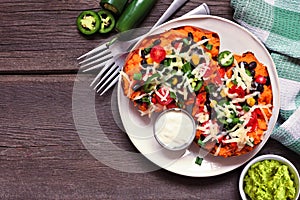 Baked sweet potato tacos, top view table scene over dark wood