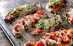 Baked sweet potato toast with roasted chickpeas, tomatoes, goat cheese, sauce guacamole, avocado, seedlings on baking tray