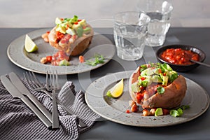 Baked sweet potatoes with avocado chili salsa and beans