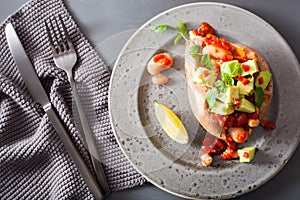 Baked sweet potatoes with avocado chili salsa and beans