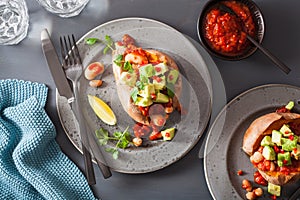 Baked sweet potatoes with avocado chili salsa and beans