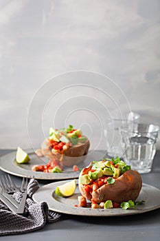 Baked sweet potatoes with avocado chili salsa and beans