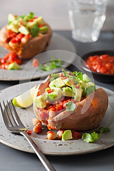 Baked sweet potatoes with avocado chili salsa and beans