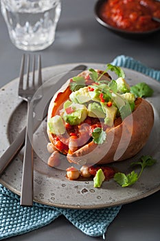 Baked sweet potatoes with avocado chili salsa and beans