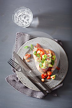 Baked sweet potatoes with avocado chili salsa and beans