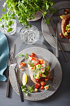 Baked sweet potatoes with avocado chili salsa and beans