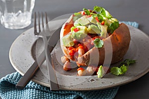 Baked sweet potatoes with avocado chili salsa and beans