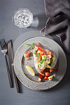 Baked sweet potatoes with avocado chili salsa and beans