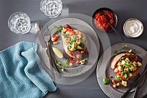 Baked sweet potatoes with avocado chili salsa and beans