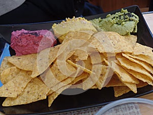 Baked tortilla chips served with a trio of vegetable dips