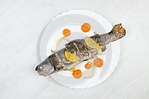 Baked trout served on the plate with vegetables