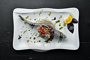 Baked trout stuffed with vegetables. Dishes, food. Top view.