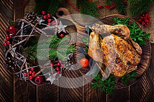 Baked turkey or chicken. The Christmas table is served with a turkey, decorated with bright tinsel.