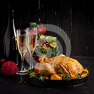 Baked turkey or chicken. The Christmas table is served with a turkey, decorated with bright tinsel. Fried chicken. Table setting.