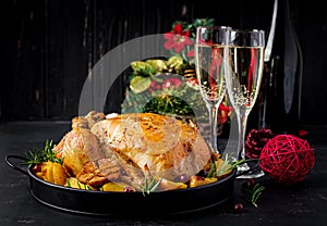 Baked turkey or chicken. The Christmas table is served with a turkey, decorated with bright tinsel. Fried chicken, table setting.