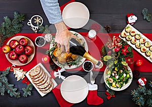 Baked turkey. Christmas dinner. The Christmas table is served with a turkey, decorated with bright tinsel and candles.