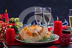 Baked turkey. Christmas dinner. The Christmas table is served with a turkey, decorated with bright tinsel and candles. Fried