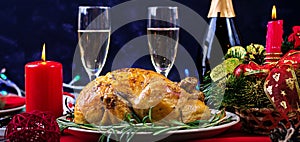 Baked turkey. Christmas dinner. The Christmas table is served with a turkey, decorated with bright tinsel and candles. Fried