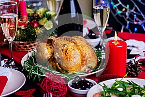 Baked turkey. Christmas dinner. The Christmas table is served with a turkey, decorated with bright tinsel and candles. Fried