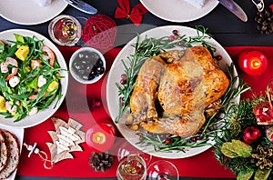 Baked turkey. Christmas dinner. The Christmas table is served with a turkey, decorated with bright tinsel and candles. Fried