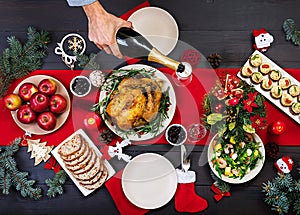 Baked turkey. Christmas dinner. The Christmas table is served with a turkey, decorated with bright tinsel and candles. Fried