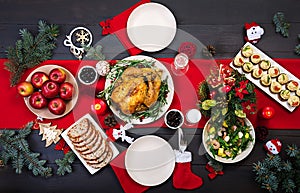 Baked turkey. Christmas dinner. The Christmas table is served with a turkey, decorated with bright tinsel and candles. Fried