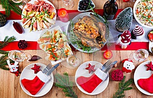 Christmas dinner. The Christmas table is served with a turkey, decorated with bright tinsel and candles. Fried chicken, table.