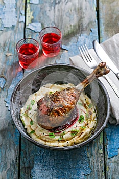 Baked turkey leg with cranberry sauce on mashed celery root, rustic style