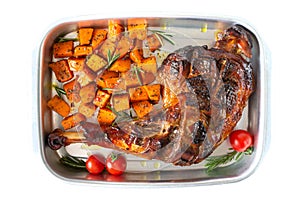 Baked turkey leg, pumpkin slices with spices in a container isolated on a white background. Thanksgiving Day. Meat dish. Top view