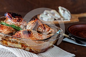 Baked turkey with potatoes in a glass dish on a wooden table. Thanksgiving Day