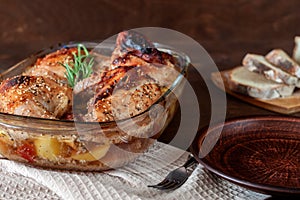 Baked turkey with potatoes in a glass dish on a wooden table. Thanksgiving Day