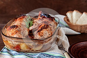 Baked turkey with potatoes in a glass dish on a wooden table. Thanksgiving Day