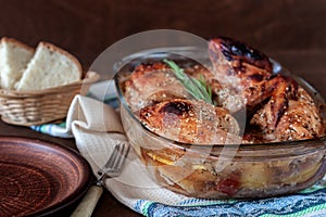 Baked turkey with potatoes in a glass dish on a wooden table. Thanksgiving Day