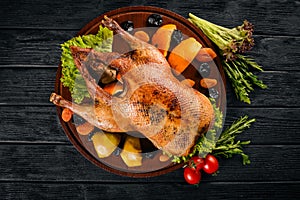 Baked turkey with vegetables and spices. Thanksgiving day. Goose chicken grill. On a wooden background.