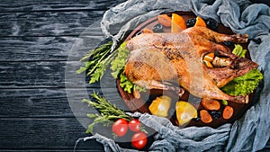 Baked turkey with vegetables and spices. Thanksgiving day. Goose chicken grill. On a wooden background.