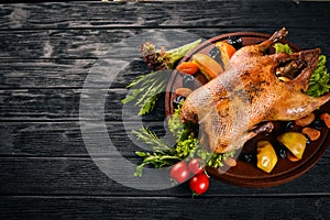 Baked turkey with vegetables and spices. Thanksgiving day. Goose chicken grill. On a wooden background.