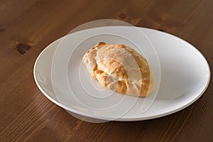 Baked vegetable pasty on a white plate