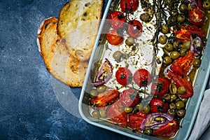 Baked vegetables with feta cheese, olives, onions, Provencal herbs, spices, olive oil and tomatoes. Home cooking concept