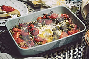 Baked vegetables with feta cheese, olives, onions, Provencal herbs, spices, olive oil and tomatoes. Home cooking concept