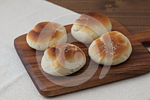 baked white bread on wood cutting board isolated on table